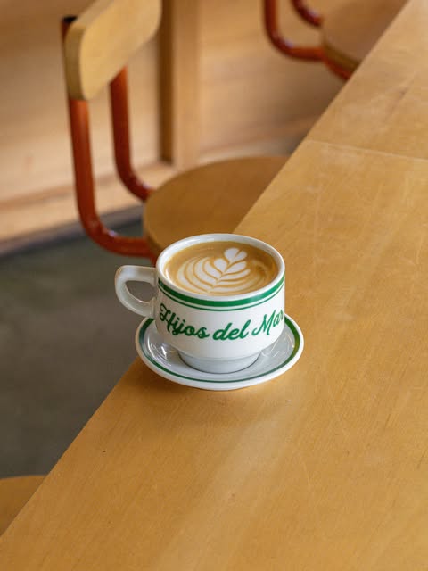 La taza de Hijos del Mar, blanca con borde verde